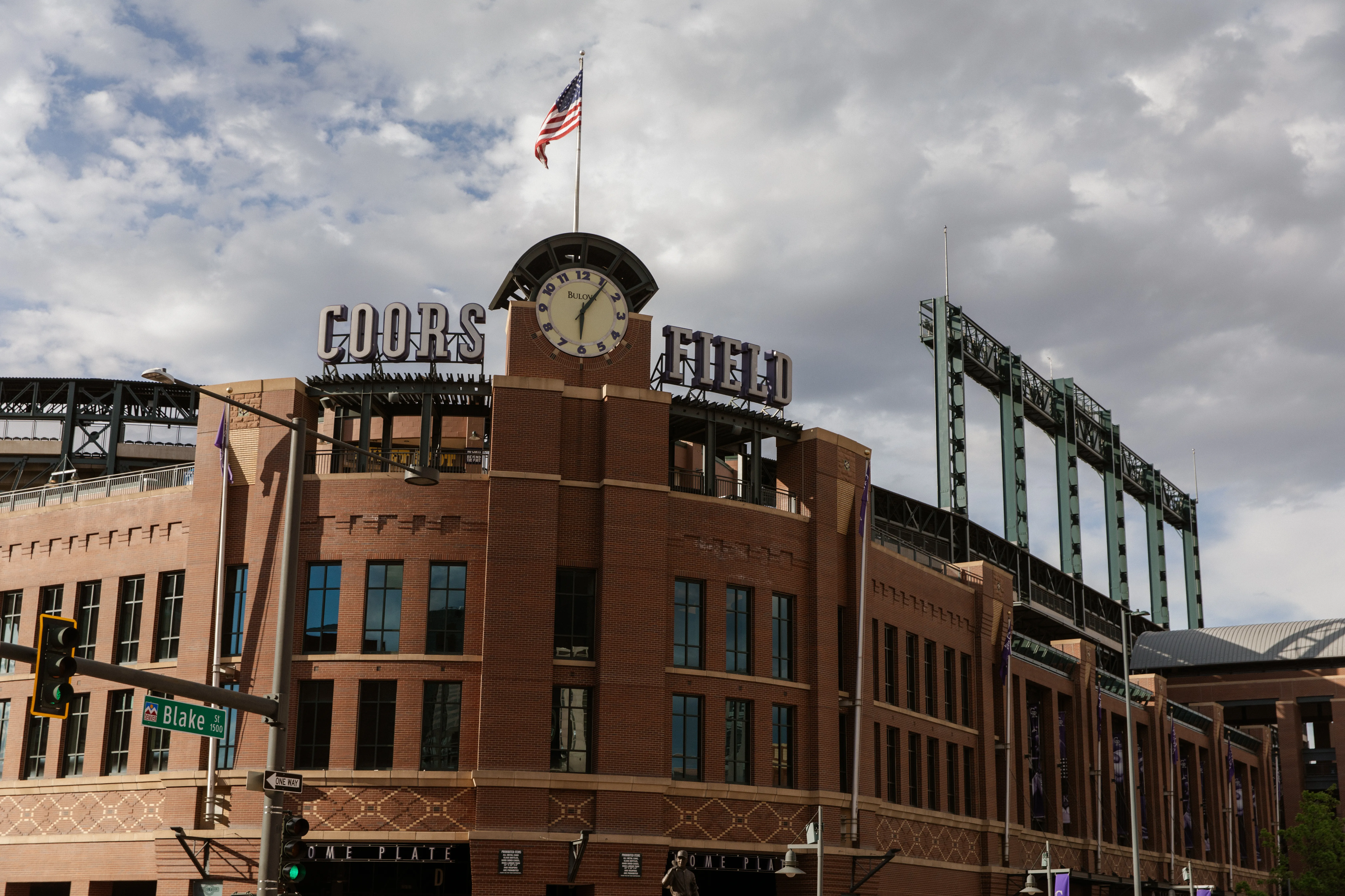 Home plate clock beneath broken clouds